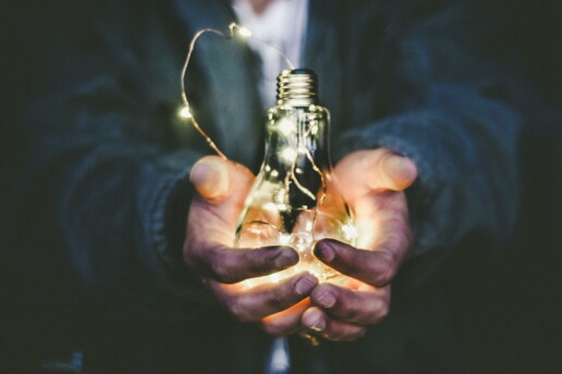 Man holding an incandescent bulb